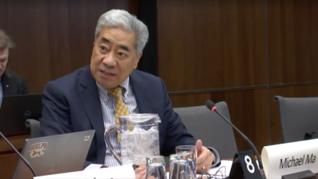 Canadian Member of Parliament Michael Ma sitting at a parliamentary committee.